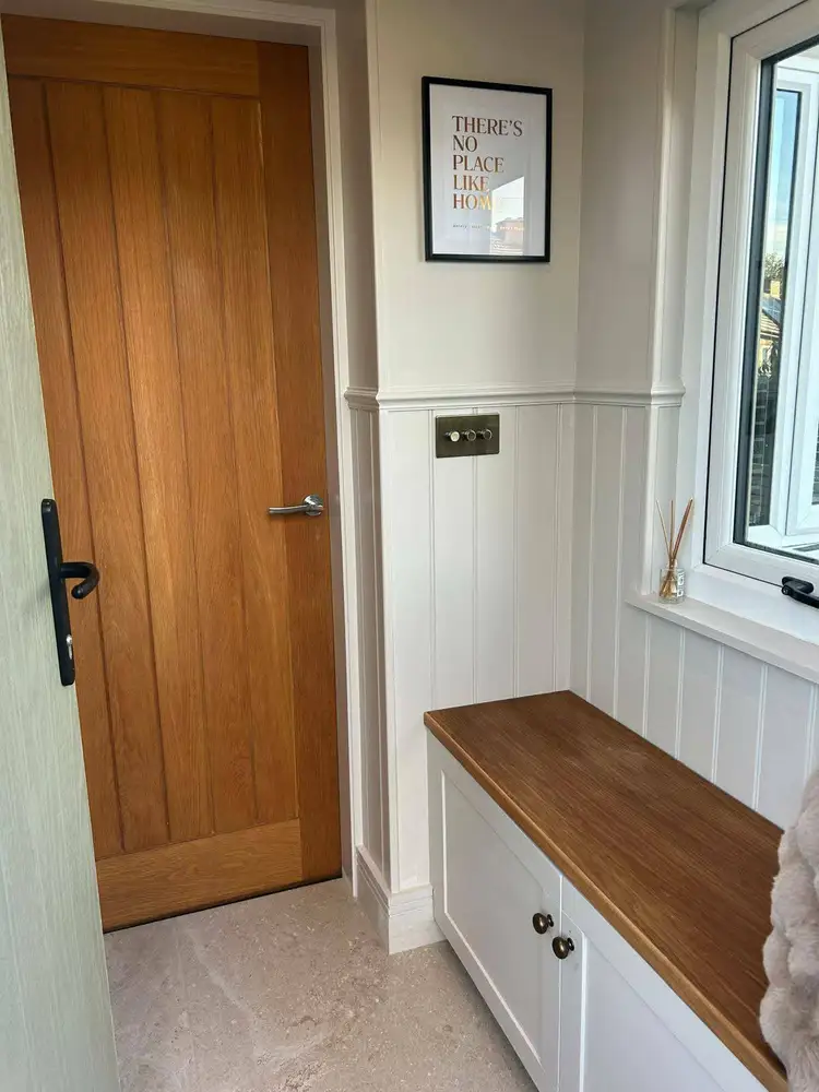 Finished hallway with oak door and fitted storage bench