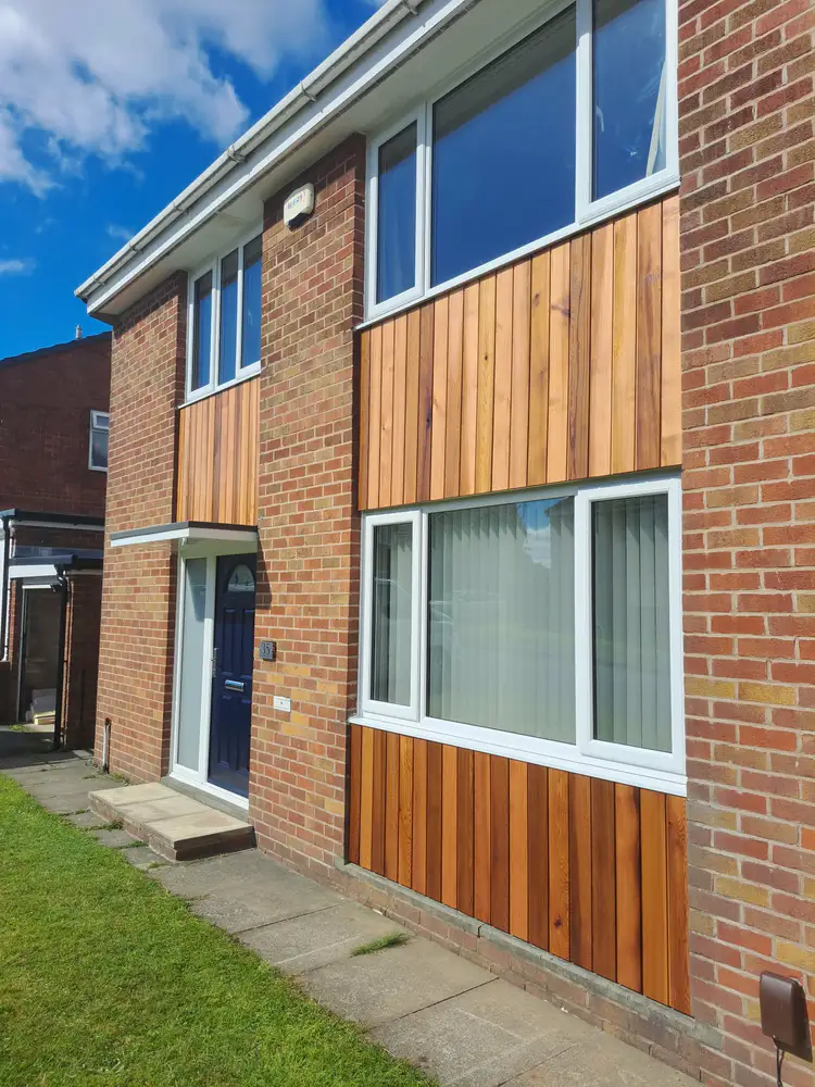 Warm timber cladding installed on a brick house