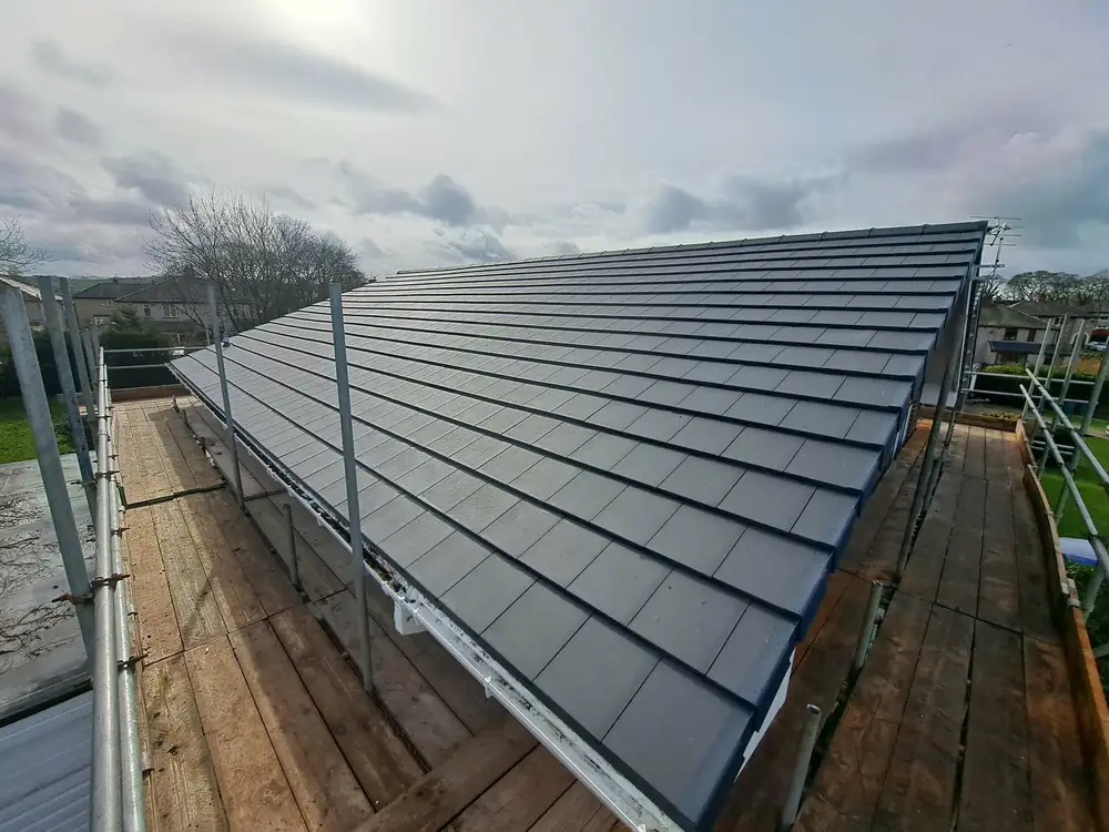 Fresh dark grey roof tiles with scaffolding in place