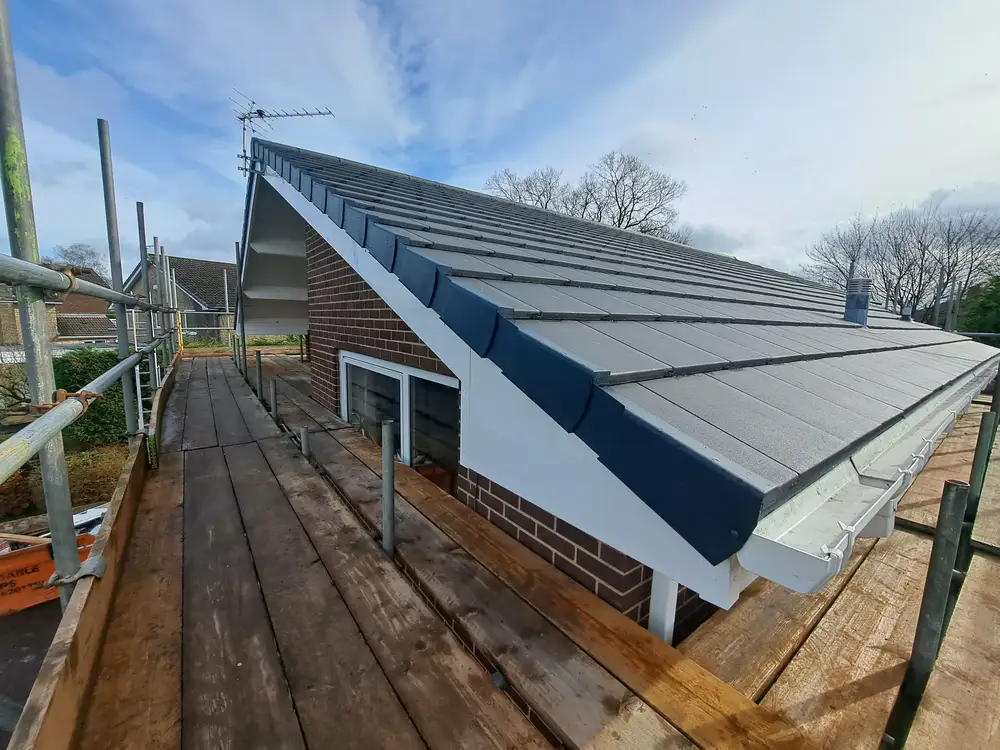 Roof installation on a residential property surrounded by scaffolding